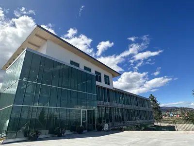 An image of a four-story city hall under a sunny sky with a few wispy clouds above